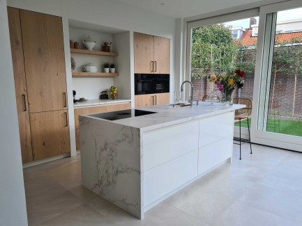 Moderne lichte eiken keuken met wit kookeiland en marmerlook kookeiland