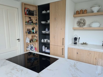 Moderne lichte eiken keuken met wit kookeiland en marmer look werkblad