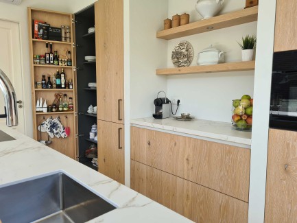 Moderne lichte eiken keuken met grote kastenwand