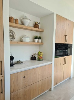 Moderne lichte eiken keuken met grote kastenwand