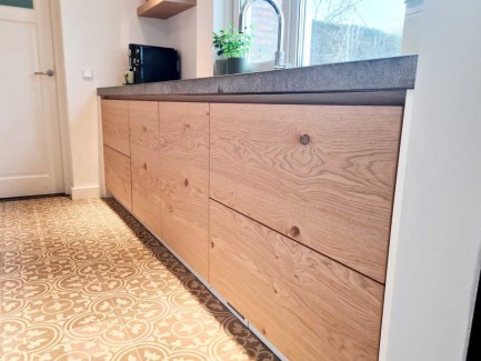 Moderne eiken keuken met doorlopende houtnerf en stenen blad