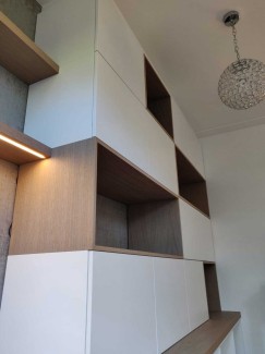 Speelse boekenkast met geïntegreerd bureau en houten kaders en witte fronten