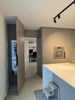 Het Calacatta Venato hoogglans werkblad Kemie BV, volledig in verstek doorgezet tegen de zijwanden, vormt één strak geheel