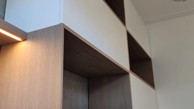 Speelse boekenkast met geïntegreerd bureau en houten kaders en witte fronten