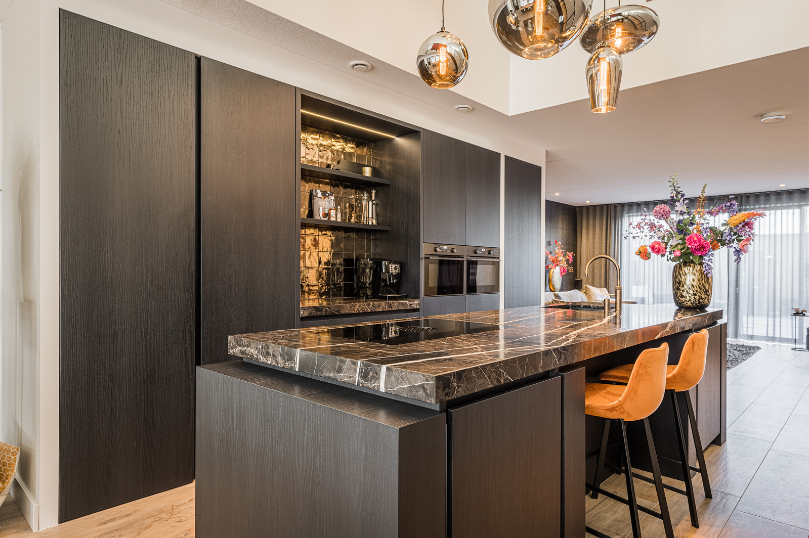 Moderne zwarte keuken met kookeiland en natuurstenen blad