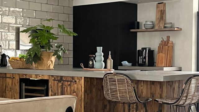 Stoere keuken met gedisselde houten fronten, stenen blad en wijnkoeler
